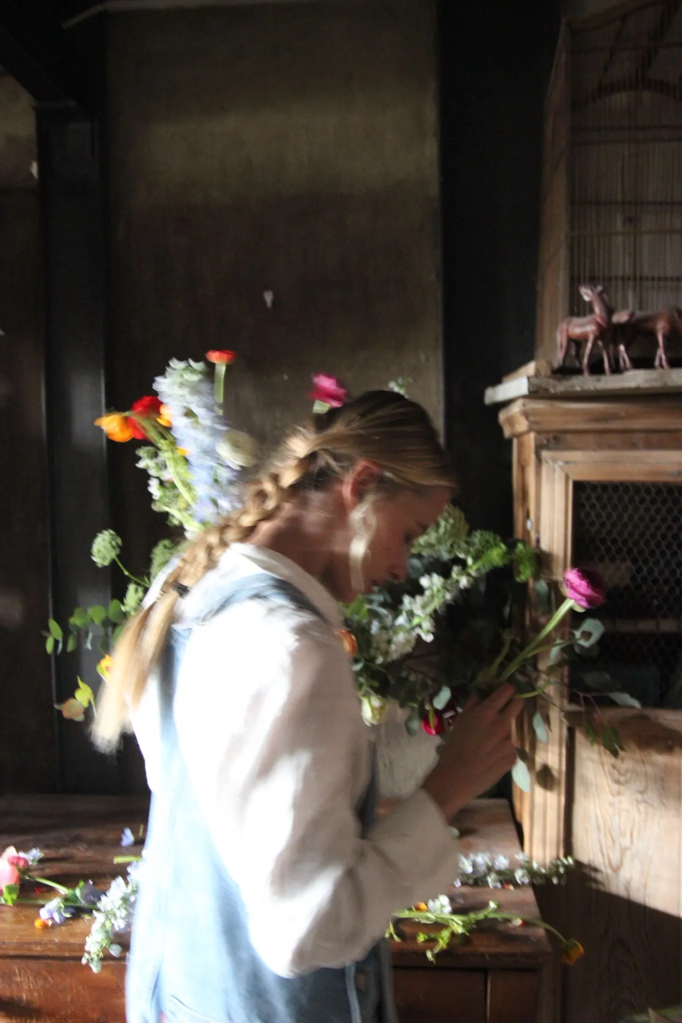 Tijeras de podar junto a ramas de tulipanes y ranúnculos dispersos sobre una mesa de madera